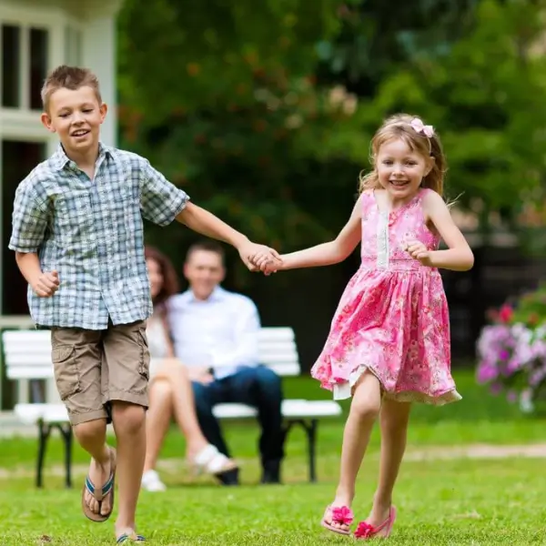 zwei Kinder toben im Garten