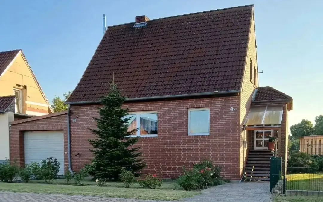 Einfamilienhaus mit Nebengelass und Garten in Klötze, Ortsteil Kunrau, Altmark – Blick auf das Backsteinhaus mit Treppe zum Eingang und Garage von der Straße aus